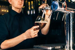 Hand die van barman een groot lagerbierbier in kraan in een restaurant of een bar gieten royalty-vrije stock afbeelding Hand die van barman een groot lagerbierbier in kraan in een restaurant of een bar gieten royalty-vrije stock afbeelding