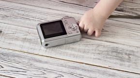 Hand för barn` s och kamera, närbild, träbakgrundsfotografi fotografering för bildbyråer Hand för barn` s och kamera, närbild, träbakgrundsfotografi fotografering för bildbyråer