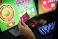 Hand holding credit card playing online gambling stock photography Hand holding credit card playing online gambling stock photography