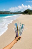Hand Holding Heap Of Plastic Straws On Ocean Beach Royalty Free Stock Photography