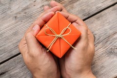 Hand Holding Orange Gift Box and Yellow Ribbon royalty free stock photos Hand Holding Orange Gift Box and Yellow Ribbon royalty free stock photos
