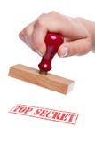 Hand holding a rubber stamp with the words Top Sec