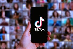 Hand holding a smartphone with TIK TOK logo