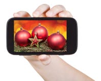 Hand holds handphone with Xmas decorations stock images Hand holds handphone with Xmas decorations stock images
