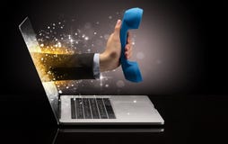 Hand med telefonen som kommer ut ur en bärbar dator royaltyfria foton Hand med telefonen som kommer ut ur en bärbar dator royaltyfria foton