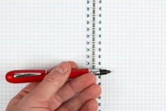 Hand met rode pen over een open notitieboekje royalty-vrije stock foto Hand met rode pen over een open notitieboekje royalty-vrije stock foto