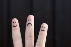 Hand mit drei unterschiedliche Emoticons gezeichnet auf Finger lizenzfreies stockbild Hand mit drei unterschiedliche Emoticons gezeichnet auf Finger lizenzfreies stockbild