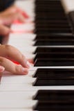 Hand op een pianotoetsenbord met rode lichten in de sleutels stock afbeeldingen Hand op een pianotoetsenbord met rode lichten in de sleutels stock afbeeldingen