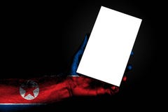 Hand with painted flag North Korea holding a large white sheet with space for an inscription, mock up stock photography Hand with painted flag North Korea holding a large white sheet with space for an inscription, mock up stock photography