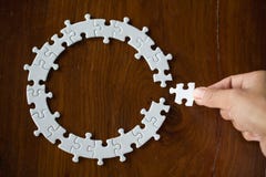 Hand placing the last jigsaw puzzle piece,conceptual of problem solving royalty free stock photography Hand placing the last jigsaw puzzle piece,conceptual of problem solving royalty free stock photography