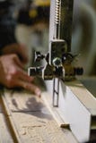 The hand saws the beam on a jigsaw machine. Top view from an angle stock images The hand saws the beam on a jigsaw machine. Top view from an angle stock images