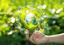 Hand som rymmer den ljusa kulan på gräsplansidor med symboler för energikälla arkivfoto Hand som rymmer den ljusa kulan på gräsplansidor med symboler för energikälla arkivfoto