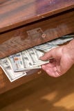 The hand taking dollars from the desk drawer. One hundred bills in desk drawer stock photo The hand taking dollars from the desk drawer. One hundred bills in desk drawer stock photo