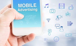 Hand touch mobile phone with mobile advertising word with feature icon at blurred grey background, Digital marketing business con stock photography Hand touch mobile phone with mobile advertising word with feature icon at blurred grey background, Digital marketing business con stock photography