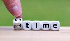 Hand is turning a dice and changes the word `full-time` to `part-time` royalty free stock image Hand is turning a dice and changes the word `full-time` to `part-time` royalty free stock image