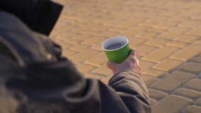 Hand van de close-up de dakloze bedelaar ` s met document kop stock footage Hand van de close-up de dakloze bedelaar ` s met document kop stock footage