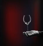 Hand in white glove and glass at black royalty free stock image Hand in white glove and glass at black royalty free stock image