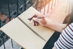 Hand of Woman in Striped shirt, white and blue.University or high school student holding pen.sitting on terrace royalty free stock photo Hand of Woman in Striped shirt, white and blue.University or high school student holding pen.sitting on terrace royalty free stock photo