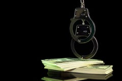 Handbojor h?ngdes p? en dollarsedel i m?rkerbakgrund fotografering för bildbyråer Handbojor h?ngdes p? en dollarsedel i m?rkerbakgrund fotografering för bildbyråer