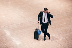 Handelsreiziger die een telefoongesprek maken terwijl het wachten op vlucht stock fotografie Handelsreiziger die een telefoongesprek maken terwijl het wachten op vlucht stock fotografie