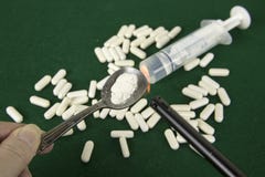 Handholding zerquetschte opiods und -feuerzeug lizenzfreies stockbild Handholding zerquetschte opiods und -feuerzeug lizenzfreies stockbild