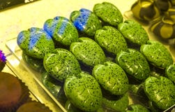 Handmade green candies in the form of monstera leafs on a show-window in shop. Tasty sweets. Supermarket, cafe. Unusual form. royalty free stock photography Handmade green candies in the form of monstera leafs on a show-window in shop. Tasty sweets. Supermarket, cafe. Unusual form. royalty free stock photography