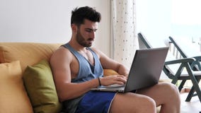 Handosme man som hemma arbetar på datorskrivbordet lager videofilmer Handosme man som hemma arbetar på datorskrivbordet lager videofilmer