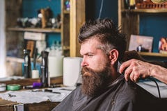 Hands of barber with clipper and comb, close up. Hipster bearded client getting hairstyle. Barbershop concept. Barber stock images Hands of barber with clipper and comb, close up. Hipster bearded client getting hairstyle. Barbershop concept. Barber stock images