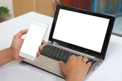 Hands of a businessman holding an empty smartphone and have blank notebook Laptop have white screen. royalty free stock images Hands of a businessman holding an empty smartphone and have blank notebook Laptop have white screen. royalty free stock images