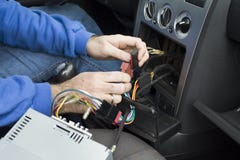 The hands of the car electrician connect the cables from the radio to the car`s electrical system. Royalty Free Stock Photos The hands of the car electrician connect the cables from the radio to the car`s electrical system. Royalty Free Stock Photos