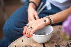 The hands of the girl touch the handmade jewelry. Girl and jewelry. Handmade woman decorating stones close up stock photography The hands of the girl touch the handmade jewelry. Girl and jewelry. Handmade woman decorating stones close up stock photography