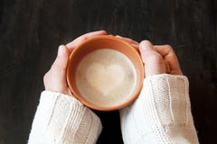 Hands Holding Cup of Coffee with Heart Shape