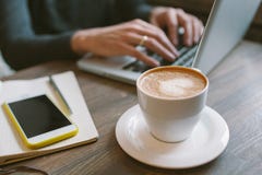 Hands of man on laptop with coffee and smartphone with notepad stock image Hands of man on laptop with coffee and smartphone with notepad stock image