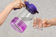Hands pouring water from a jug into a glass royalty free stock photo Hands pouring water from a jug into a glass royalty free stock photo