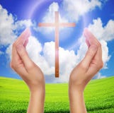 Hands praying with cross in sky - easter concept