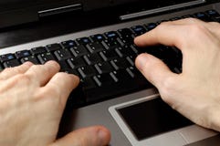 Hands typing on laptop computer keyboard communication concept