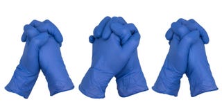 Hands wearing blue nitrile examination gloves clasped together in a posture of prayer