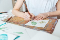Hands of woman artist painting with paintbrush and watercolor paints Stock Images Hands of woman artist painting with paintbrush and watercolor paints Stock Images