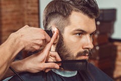 The hands of young barber making haircut to attractive man in barbershop royalty free stock photo The hands of young barber making haircut to attractive man in barbershop royalty free stock photo