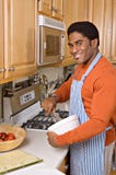 Handsome African-American man cooks in kitchen stock images Handsome African-American man cooks in kitchen stock images