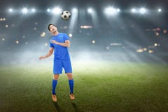Handsome asian male football player trying to heading the ball stock photos Handsome asian male football player trying to heading the ball stock photos