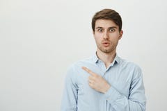 Handsome athletic adult unshaved guy standing with crossed hands, being calm and confident over gray background. English royalty free stock photo Handsome athletic adult unshaved guy standing with crossed hands, being calm and confident over gray background. English royalty free stock photo