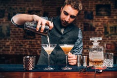 Handsome Barman creating professional cocktails. Details of alcoholic drinks and beverages at pub or bar stock images Handsome Barman creating professional cocktails. Details of alcoholic drinks and beverages at pub or bar stock images