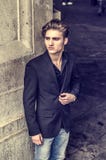Attractive blue eyed, blond young man leaning against white wall Royalty Free Stock Photography Attractive blue eyed, blond young man leaning against white wall Royalty Free Stock Photography