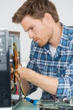 Handsome computer engineer repairing faulty pc Royalty Free Stock Photography Handsome computer engineer repairing faulty pc Royalty Free Stock Photography