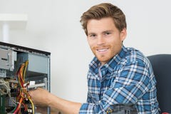 Handsome computer engineer repairing faulty pc Stock Images Handsome computer engineer repairing faulty pc Stock Images