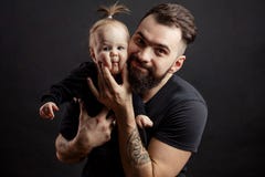Young athletic father with adorable baby on black background royalty free stock photography Young athletic father with adorable baby on black background royalty free stock photography