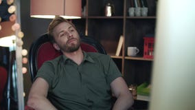 Handsome man leaning back from computer. Employee falling from broken chair stock footage Handsome man leaning back from computer. Employee falling from broken chair stock footage