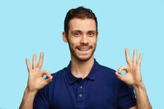 A handsome man showing ok sign isolated on blue background royalty free stock photos A handsome man showing ok sign isolated on blue background royalty free stock photos