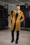 Handsome man stands in suit shop fashionable rich male dressed in expensive clothes posing indoors stock photo Handsome man stands in suit shop fashionable rich male dressed in expensive clothes posing indoors stock photo